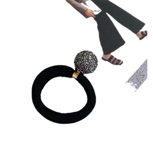 Elastic hair tie featuring a dark gray multifaceted crystal ball with gold metal link