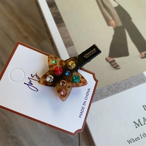Vue macro détaillée d'une barrette étoile en écaille de tortue avec strass colorés