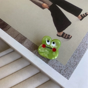 Detail showing the glossy green acetate monster claw clip with funny cartoon eyes