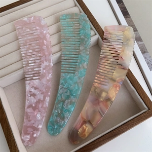 Macro shot of assorted thick acetate hair combs with elegant marble patterns in jewelry tray