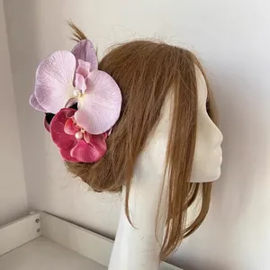 Detail view of large faux Phalaenopsis orchid hair clip with pink purple petals and pearls