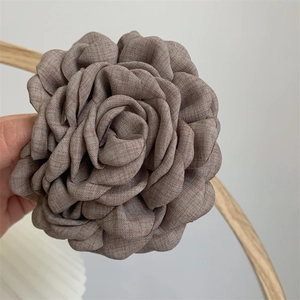 Detail of a large fabric hair claw with layered petals in retro dried rose pink finish