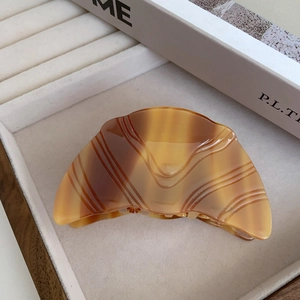 Détail d'une grande pince à cheveux en acétate écaille de tortue au design de croissant