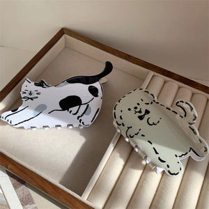 Pinces à cheveux en acétate motif chat et chien sur un plateau à bijoux en velours