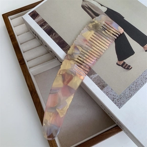 Detail of premium marble-textured acetate hair comb with pink and cream pearlescent finish