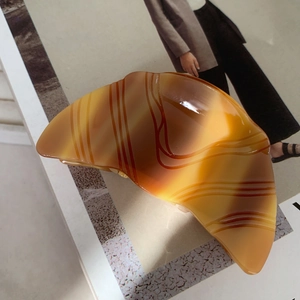 Gros plan d'une pince à cheveux réaliste en forme de croissant en acétate brillant