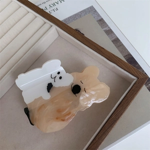 Détail de la pince à cheveux en acétate motif koala et chiot sur plateau à bijoux
