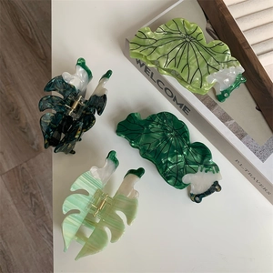 Vue à plat de quatre pinces à cheveux uniques en acétate marbré en forme de feuilles