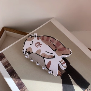 Détail macro d'une pince à cheveux créative en acétate brillant en forme de chat roux