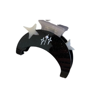 Pince à cheveux lune noire scintillante avec motifs étoiles et perle sur fond blanc