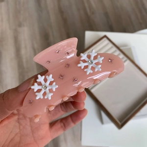 Gros plan sur la pince à cheveux rose flocon de neige avec strass et finition acétate