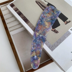 Macro detail of ergonomic acetate hair comb with colorful marble texture pattern