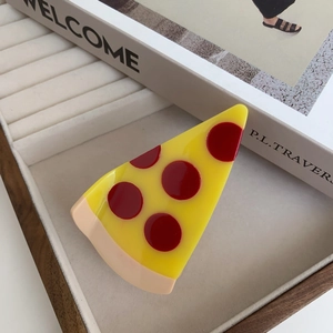 Gros plan d'une pince à cheveux créative en forme de pizza dans une boîte à bijoux