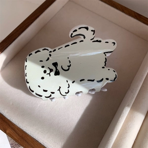 Détail d'une pince à cheveux en forme de chiot dessin animé dans un écrin à bijoux en velours