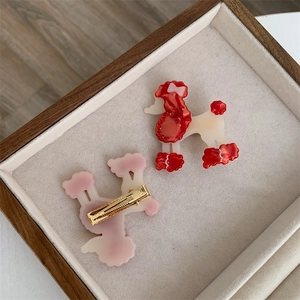 Detail von roten und rosa Pudel-Haarspangen mit Strass auf einem Samt-Display-Tablett