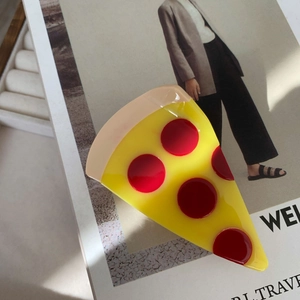 Pince à cheveux créative en acétate en forme de pizza sur fond de magazine de mode