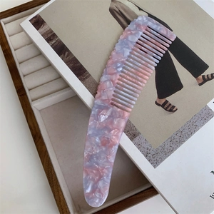 Detailed macro view of thick acetate hair comb with pink and blue marble pattern