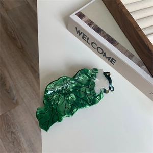 Détail de la pince à cheveux feuille de lotus verte avec veines et texture