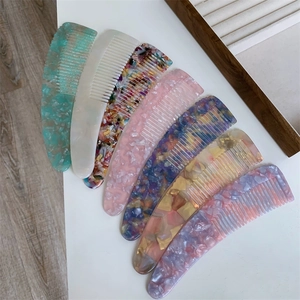 Detailed overhead view of multiple tortoiseshell pattern acetate hair combs in various colors