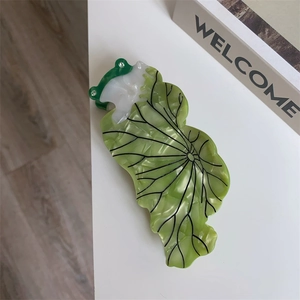 Détail de la pince à cheveux grenouille sur nénuphar vert avec fleur et cristaux
