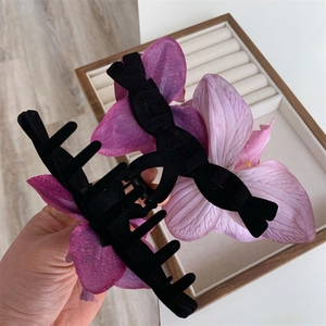 Close-up of elegant orchid hair clips with realistic pink and purple fabric petals