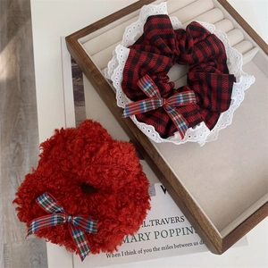 Red plaid lace scrunchie and plush bow hair tie set on a wooden display tray