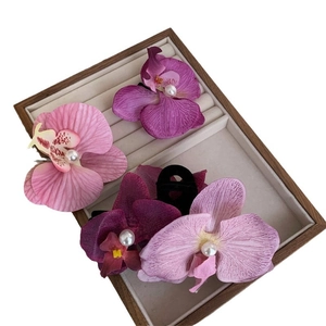 Realistic Phalaenopsis orchid hair clips in pink and purple with pearl centers