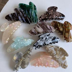 Flat lay of large acetate hair claws in various vintage marble and tortoiseshell textures