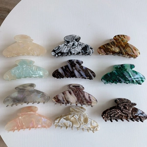Detail view of large acetate hair claws featuring diverse marble and tortoiseshell textures