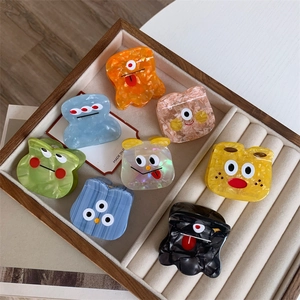 Colorful acetate monster hair claws with cartoon eyes in a wooden jewelry tray