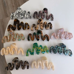 Oversized acetate hair claws set featuring wavy curves and vintage tortoise patterns