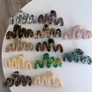 Macro view of assorted wavy acetate claw clips in various tortoiseshell and marble patterns