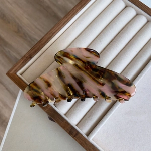 Close-up of a large tortoiseshell acetate claw clip with marble texture on velvet