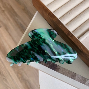 Detailed texture of high-quality large green acetate hair claw clip for thick hair styling