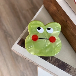 Detailed macro view of the cute green frog acetate hair claw clip with marble texture