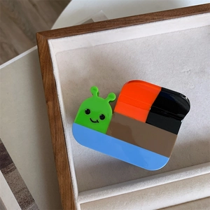Détail d'une pince à cheveux escargot au design color-block en acétate coloré