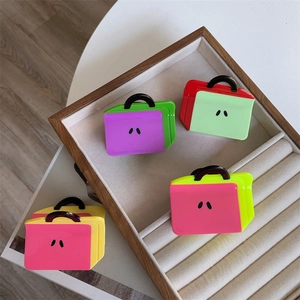 Detail showing set of four colorful acetate handbag shaped hair claws with vibrant colors