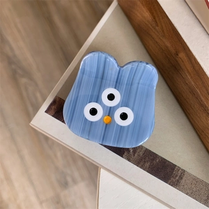 Close-up of cute blue cartoon monster claw clip with smooth acetate striped finish