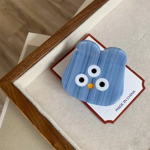 Detail of cute light blue acetate hair claw clip featuring an alien monster design