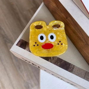 Macro detail of cute cartoon bear hair claw clip made of marbled yellow acetate