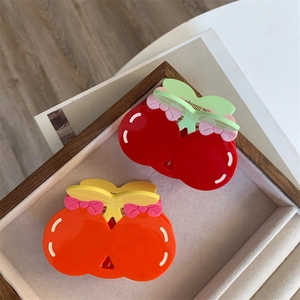 Sweet acetate cherry hair claws in red and orange colors on a velvet jewelry tray
