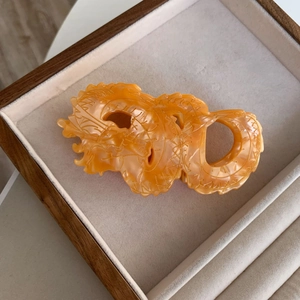 Detailopname van de oranje acetaat draken haarklem op een luxe sieraden plateau