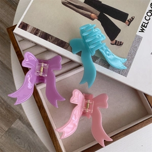 Macro shot of high-quality acetate hair claws in pastel bow shapes with metal springs