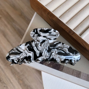 Detailed view of large acetate hair claw with black and white marble ink texture