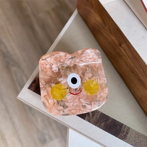 Detail view of pink marble acetate hair claw clip featuring a cute cartoon smiley face design