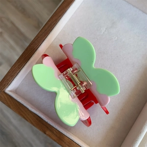 Detail of butterfly claw clip made of acetate with pink and green floral color blocking