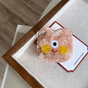Detail of pink marble acetate hair claw with cute cartoon face and smooth texture