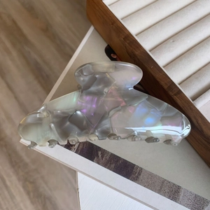 Detail of large acetate shark hair claw clip with colorful pearlescent texture on a jewelry box