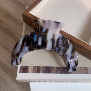 Detailed macro view of the marble texture on a crescent moon acetate hair claw clip