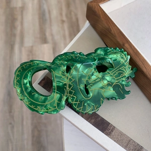 Groene acetaat draak haarklem met gouden patroon en marmeren textuur in haarsieraden-stijl